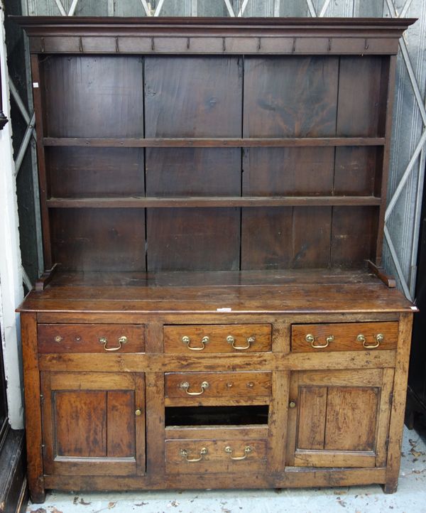 A George III and later oak dresser, the enclosed two tier plate rack over four true and two dummy drawers, flanked by cupboards, 156cm wide x 186cm hi