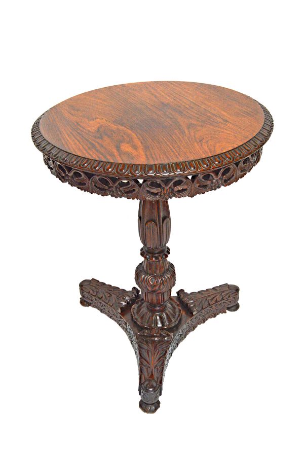 A 19th century Anglo-Indian profusely carved rosewood circular snap top occasional table, on triform base, 61cm wide x 73cm high.   Illustrated