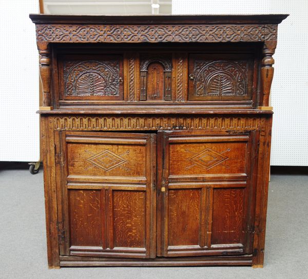 An early 17th century and later oak court cupboard, with pair of upper doors flanking an arched panel, over two lower panel doors, 150cm wide x 162cm