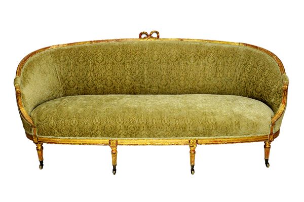 A 19th century French gilt framed tub back sofa, with ribbon tied crest on reeded supports, 221cm wide x 101cm high.   Illustrated