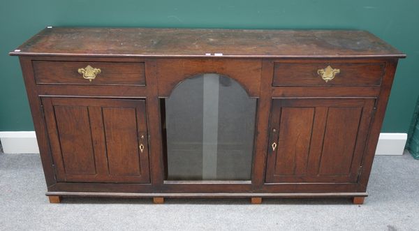 A late 18th century oak dog kennel dresser base, with central recess flanked by pair of drawers and cupboards, 164cm wide x 44cm deep.