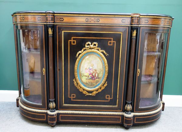 A Victorian gilt metal mounted figured walnut and ebonised credenza, the central door with ceramic plaque mount flanked by rounded glazed doors, 166cm