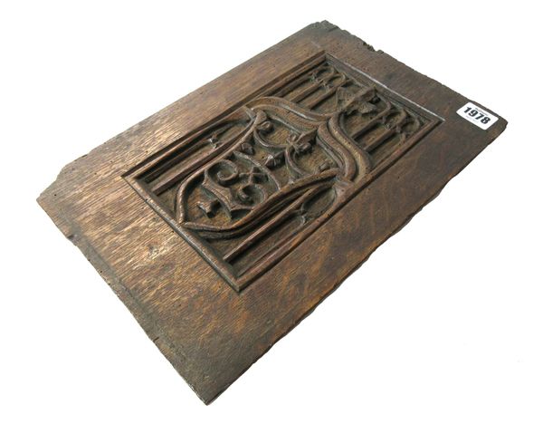 A 17th century oak blind tracery panel, relief carved with an armorial crest, 23.5cm wide x 34.5cm high.