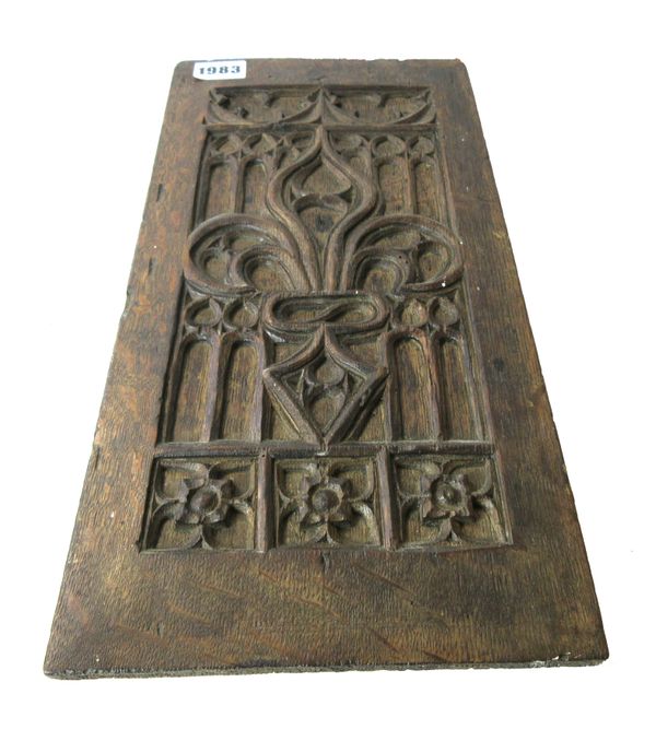 A 17th century French oak blind tracery panel, relief carved with fleurs de lis, 18cm wide x 37.5cm high.