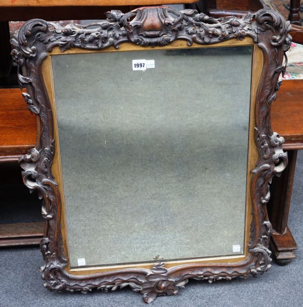 A 19th century mahogany wall mirror with carved floral chased shaped frame, 67cm wide x 81cm high.