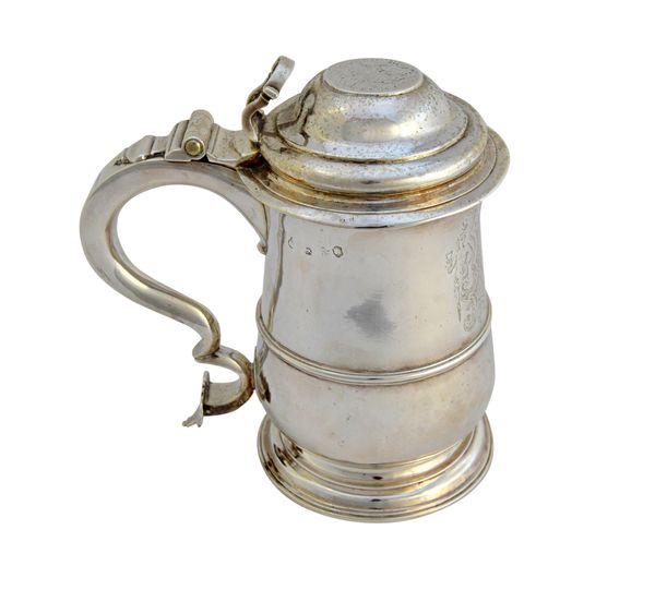 A silver hinge lidded tankard, mid 18th century, of baluster form, the scrolling handle tapering as a heart shaped terminal and with a loop shaped thu