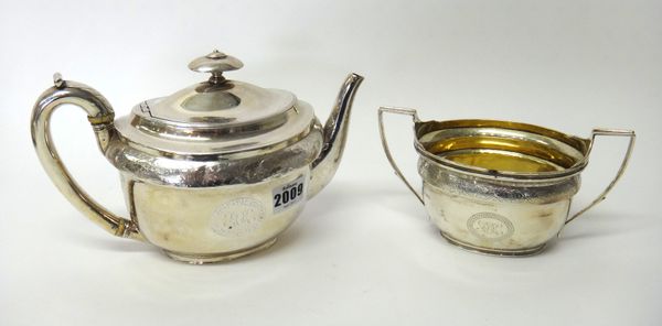 Silver, comprising; a George III teapot, of oval form, decorated with an engraved band and with an initialled oval cartouche, London 1804 and a twin h