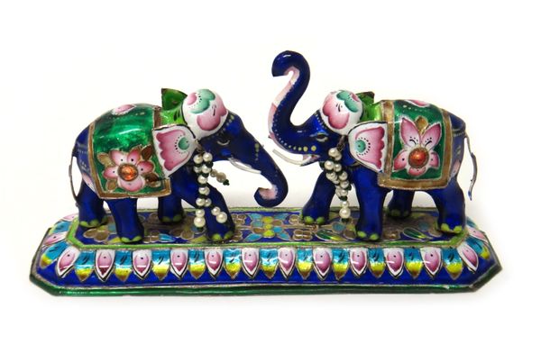 An Indian enamelled model of two elephants, mounted with rows of imitation pearls and green glass beads, detailed SILVER, modern, loaded, length 17cm.