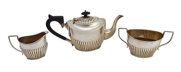 A silver three piece tea set, comprising; a teapot, a twin handled sugar bowl and a milk jug, each piece of oval form with partly fluted decoration, C