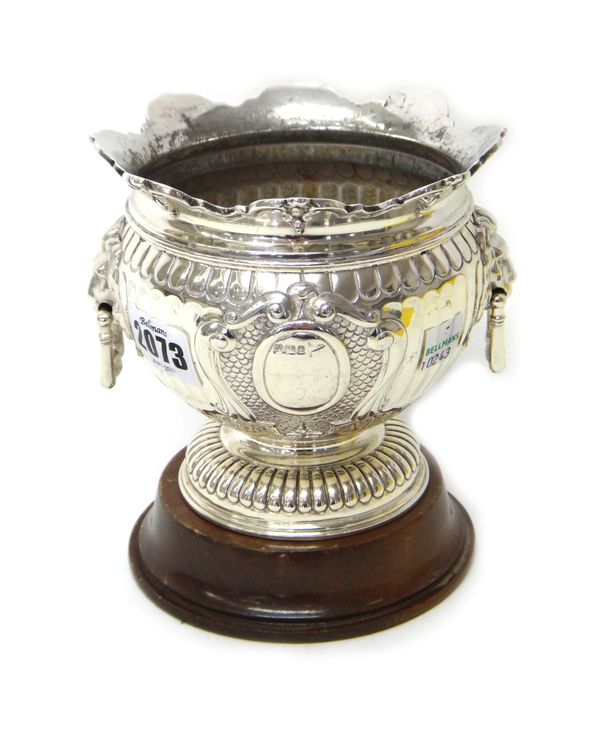 A silver twin handled trophy bowl, with partly fluted decoration, lion mask and loop shaped handles, within an arcaded cast rim and on a fluted circul