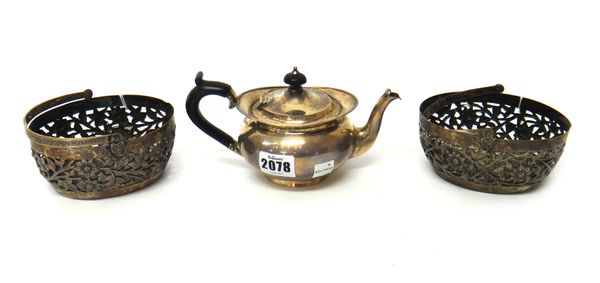 A silver small teapot, of compressed circular form, with black fittings, London 1906, gross weight 245 gms and a pair of oval baskets, with pierced fl