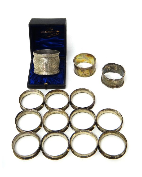 A Victorian silver napkin ring, with engraved decoration within beaded rims, London 1893, with a case and thirteen further silver napkin rings, includ