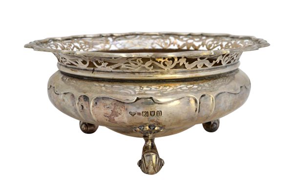 A silver shaped circular bowl, the curved rim with scroll pierced decoration and raised on three scrolling feet, by Goldsmiths & Silversmiths Co, Lond