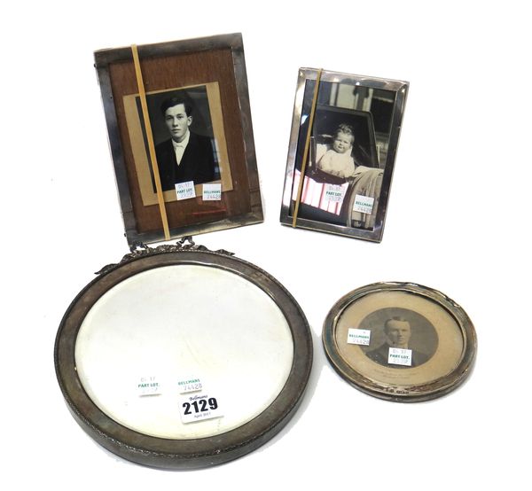 A silver mounted circular mirror, with a bow surmount, fitted with a bevelled mirror, London 1911, a silver mounted circular photograph frame, Birming