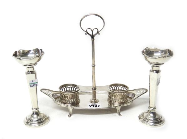 A Victorian silver twin bottle boat shaped cruet stand, with pierced decoration, loop shaped handle and raised on four feet (the two bottles lacking),