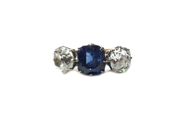 A gold, sapphire and diamond set three stone ring, claw set with the octagonal step cut sapphire at the centre, between two cushion shaped diamonds, d