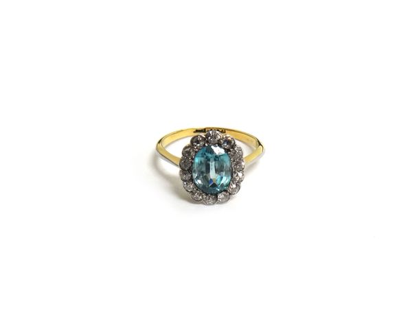 A blue zircon and diamond fifteen stone cluster ring, mounted with the oval cut blue zircon at the centre in a surround of fourteen cushion shaped dia