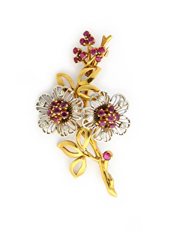 A two colour gold, ruby and diamond brooch, designed as a floral and foliate spray, mounted with circular cut rubies and diamonds, gross weight 14.4 g