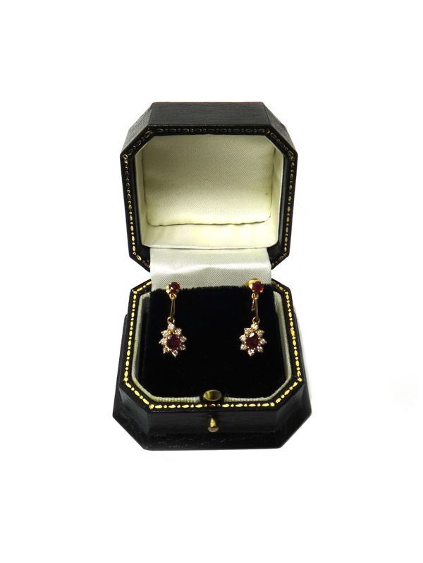 A pair of gold, ruby and diamond set pendant earrings, each drop claw set with a pear shaped ruby within a surround of circular cut diamonds and with