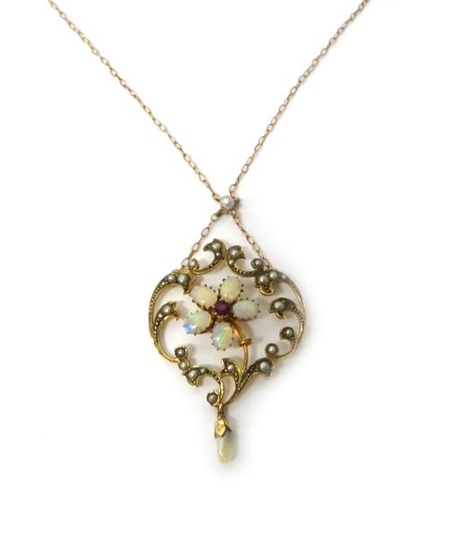A gold, opal, ruby and seed pearl set pendant necklace, with a cinquefoil motif at the centre, within a scroll pierced surround, the front with a fres