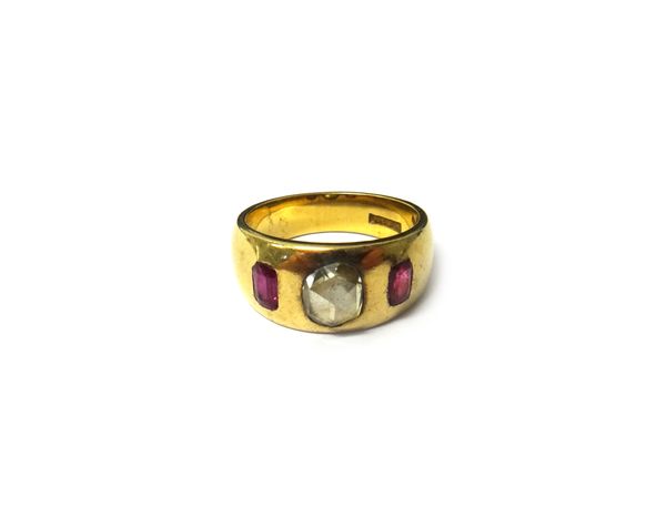 A gold, ruby and diamond set three stone ring, gypsy set with the rose cut diamond at the centre, between two cushion shaped rubies, detailed 18, ring