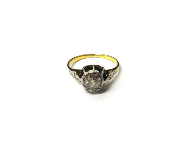 A gold and diamond set single stone ring, mounted with a cushion shaped diamond, between decorated shoulders, ring size I.