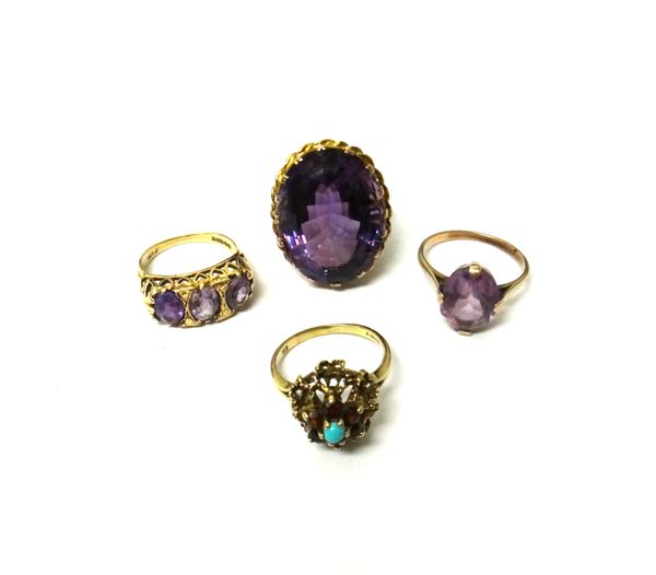 A gold ring, claw set with an oval cut large amethyst, a 9ct gold and amethyst set three stone ring, a gold ring, claw set with an oval cut amethyst a