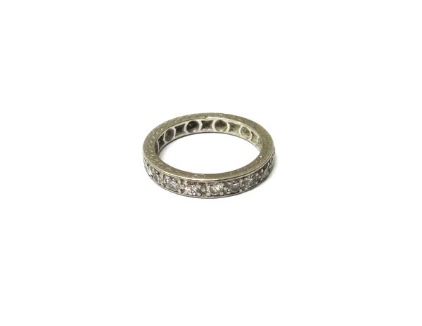 A platinum and diamond set full eternity ring, mounted with circular cut diamonds, the mount decorated with engraved sides, ring size P.