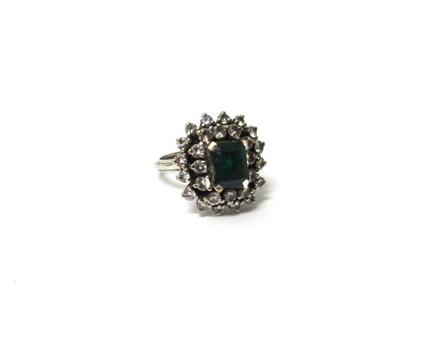 An 18ct white gold, emerald and diamond cluster ring, claw set with the cut cornered rectangular cut emerald at the centre, in a two tier surround mou