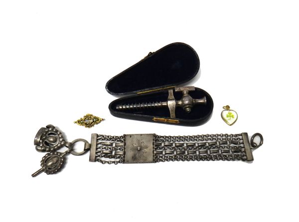 A multiple row fob chain fitted with a pendant watch key and a fob and having a central panel with floral decoration, a small gold brooch, a heart sha