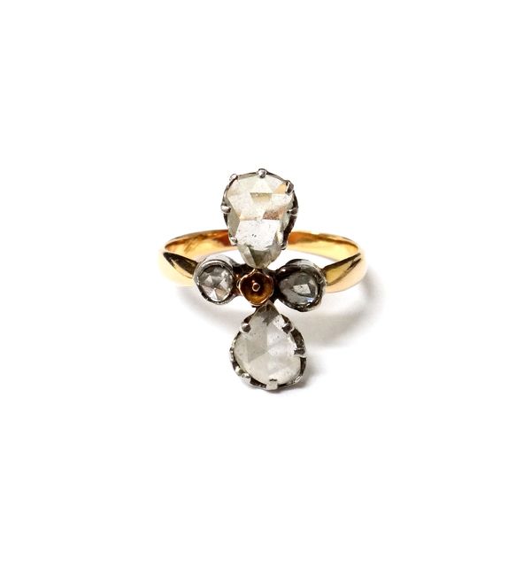 A gold ring, mounted with two pear shaped rose diamonds and with two small rose diamonds to the sides, ring size L.   Illustrated