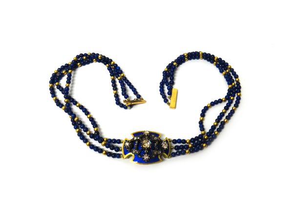 A gold, rose diamond, blue enamelled and lapis lazuli bead necklace, the front curved cruciform panel with a rose diamond set central motif, in a scro