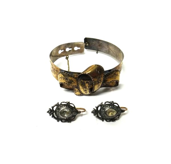 A silver bracelet, the front with a tied bow motif, engraved with floral sprays, possibly French and a pair of silver and colourless paste set earring