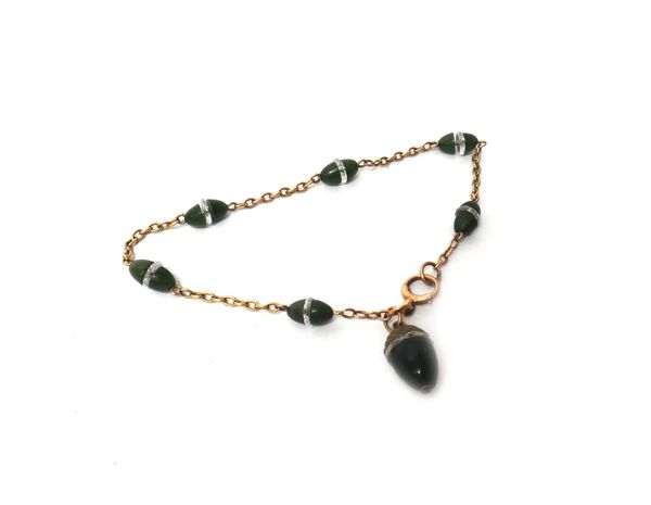 A gold and nephrite bracelet, the oval link chain spaced with nephrite beads with faceted divisions at intervals and with a nephrite pendant formed as