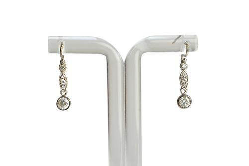 A pair of diamond set pendant earrings, each collet set with the principal circular cut diamond to the drop, diamond single stone surmount and with a