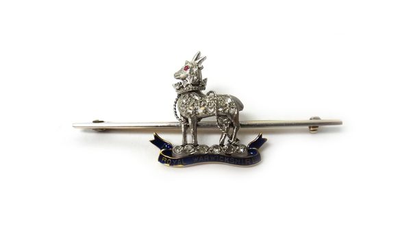 A gold, diamond set and blue enamelled military brooch badge, designed as the badge of The Royal Warwickshire Regiment, the body of the antelope mount