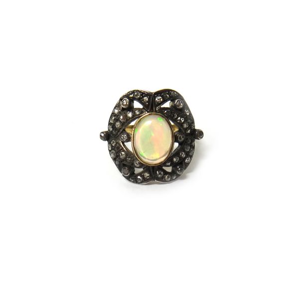 A gold and silver, opal and diamond set panel shaped ring, collet set with the oval opal at the centre, within a pierced surround mounted with rose cu