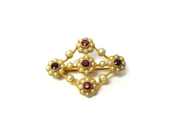 A gold, ruby and seed pearl set brooch in the form of five flowerhead shaped clusters, otherwise in an openwork design, gross weight 4.6 gms.  MS2-334