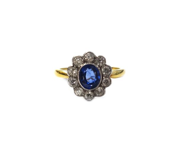 A gold, diamond and sapphire set eleven stone oval cluster ring, collet set with the oval cut sapphire at the centre, in a surround of ten circular cu