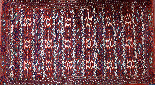 A Yumut carpet, the field with bands bearing guls, a minor diamond border, skirt end, 308cm x 172cm.  Illustrated