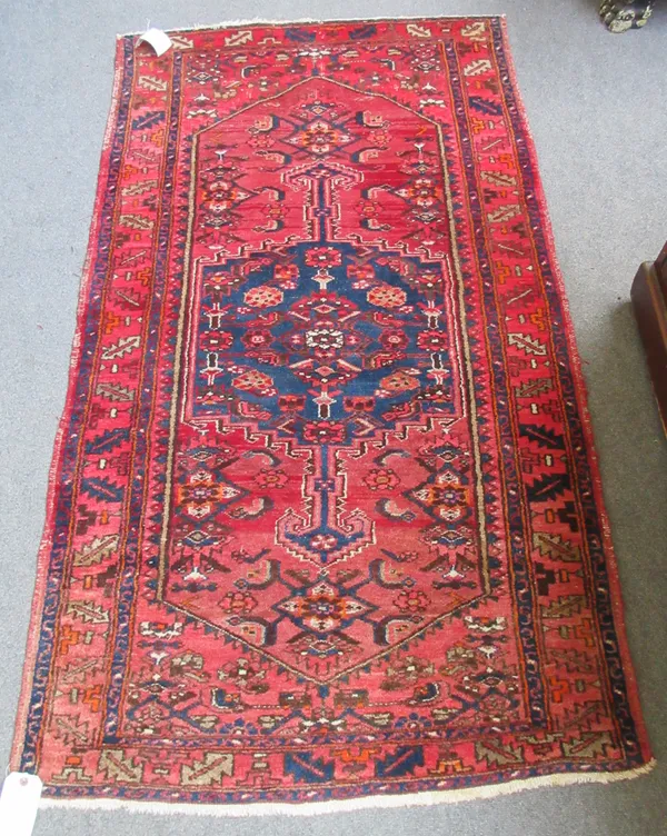 An Afghan rug, the madder field with two columns of fourteen guls, a cross border, 190 x 104cm and a Hamadan rug, Persian, the madder field with a bol