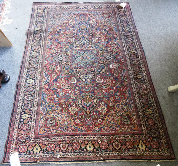 A pair of Teheran rugs, Persian, each madder field with a dark and pale indigo medallion, indigo spandrels, all with abundant floral sprays, a complem