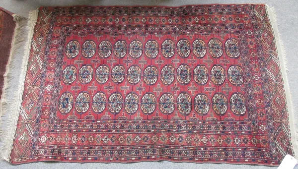 A Tekke Turkman rug, the madder field with three columns of nine guls, stylised crosses, three borders, and a Tekke Turkman rug, the madder field with