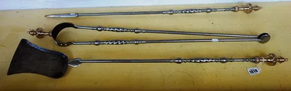 A set of Georgian steel and brass mounted fire irons, each with wrythen twist and knopped decoration to the plain tapering shaft, comprising; shovel (