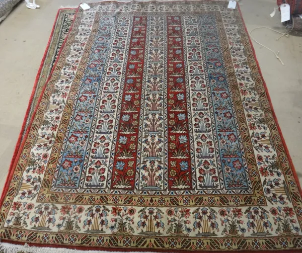 A Ghom rug, Persian, the field with columns of floral design, an ivory floral border, 138cm x 196cm.