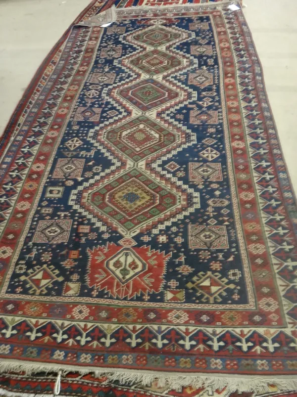 A Karagashi runner, Caucasian, the dark indigo field with five diamonds supported by pairs of square motifs, two borders, 317cm x 150cm.