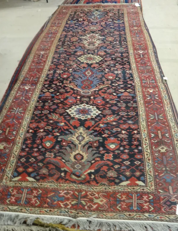 A Bakhtiari Kelleh, Persian, the dark indigo field with a central column of medallions, all with floral sprays, a madder lily and flower border, 360cm
