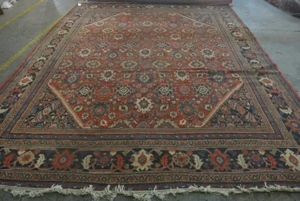 A Mahal carpet, Persian, the madder field with an allover design of palmette and floral sprays, black matching spandrels, a black palmette, leaf and v