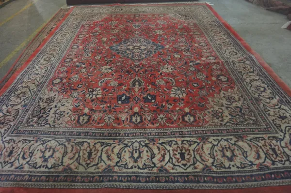A Mahal carpet, Persian, the madder field with a pale indigo diamond, fawn spandrels, all with palmettes and floral vine sprays, an indigo palmette an