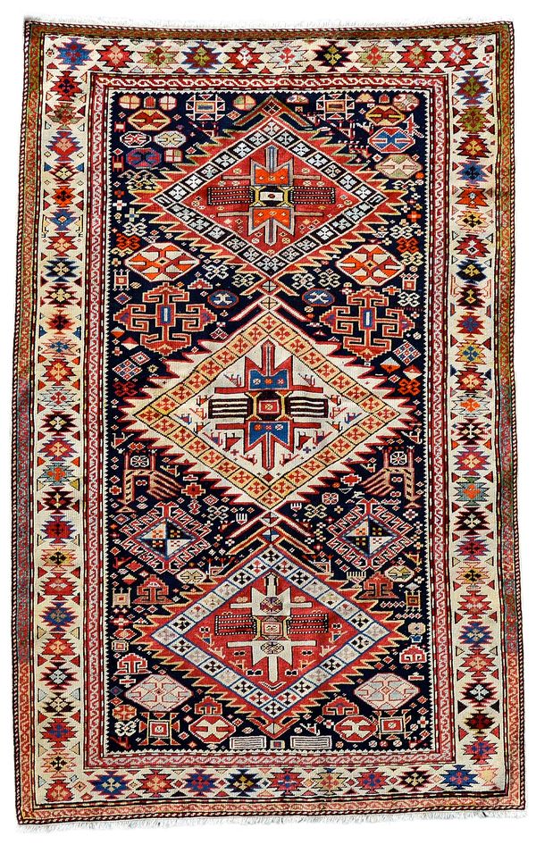 A Shirvan rug, Caucasian, the black field with an ivory and two madder stepped diamonds, all with birds, minor motifs, a pair of peacocks and other pa